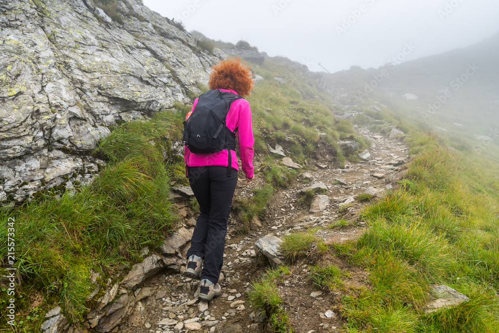 Woman hiking into rocky mountains