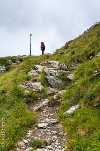 Woman hiking into rocky mountains