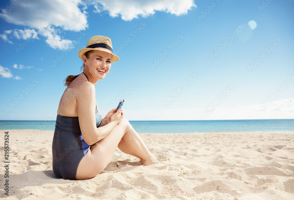 happy young woman in beachwear with smartphone on seashore happy young woman in beachwear with smartphone on seashore