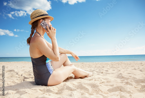 Wallpaper Mural young woman in swimwear on beach talking on cell phone Torontodigital.ca