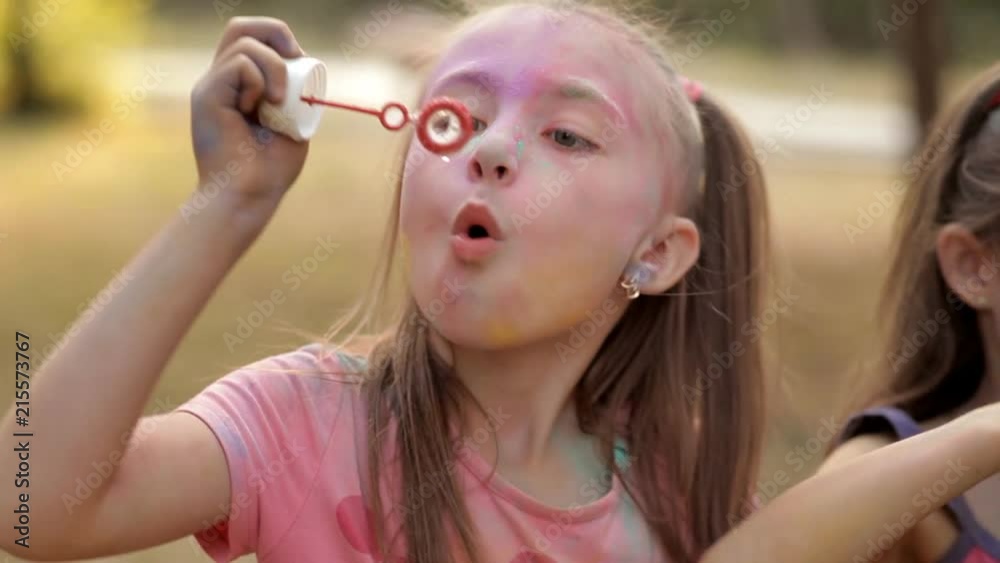 In the recreation park, children blow bubbles. Children's entertainment in the recreation park. Holiday holi In the recreation park, children blow bubbles. Children's entertainment in the recreation park. Holiday holi