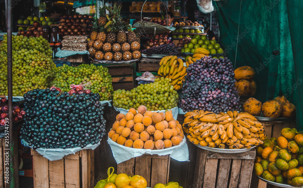Fresh, organic fruit piled up in bowls in a packed street market stall in Bolivia
