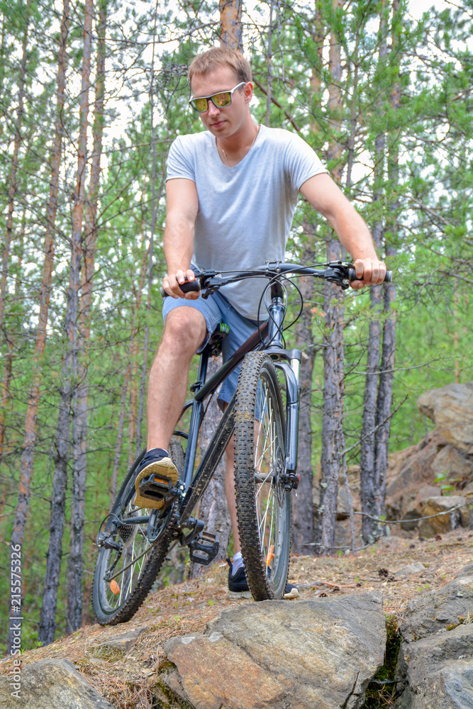 Obraz premium athlete on a bike among the rocky terrain.Healthy lifestyle.Walking by bike