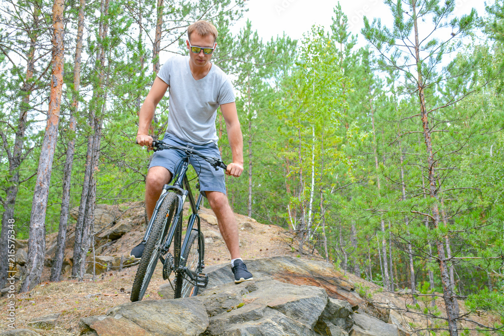 Naklejka premium athlete on a bike among the rocky terrain.Healthy lifestyle.Walking by bike