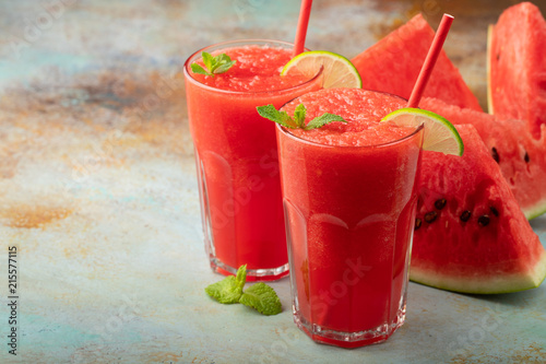 Watermelon slushie with lime, summer refreshing drink in tall glasses on a blue rusty background. with copy space