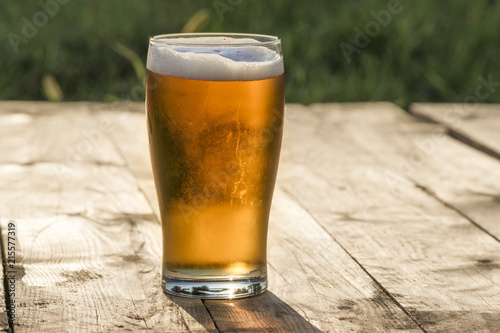 Szklanka piwa na drewnianym blacie. photo