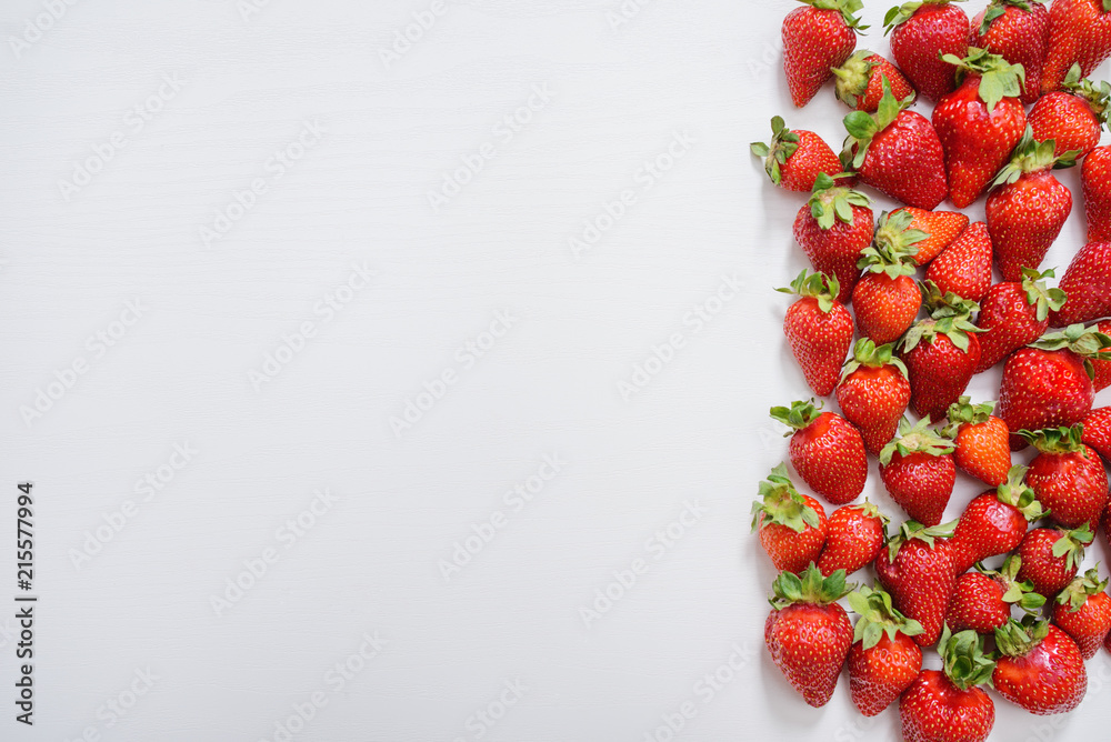strawberry fruits on the right side on wooden background with copy space. View from above.