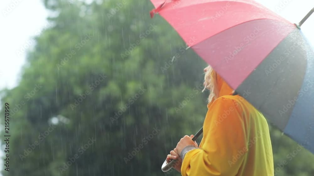 happy young attractive girl holding colorful umbrella while walking outdoors in rainy day cute smile enjoyment carefree happiness online weather forecast bright summer fashion look leisure funny mood