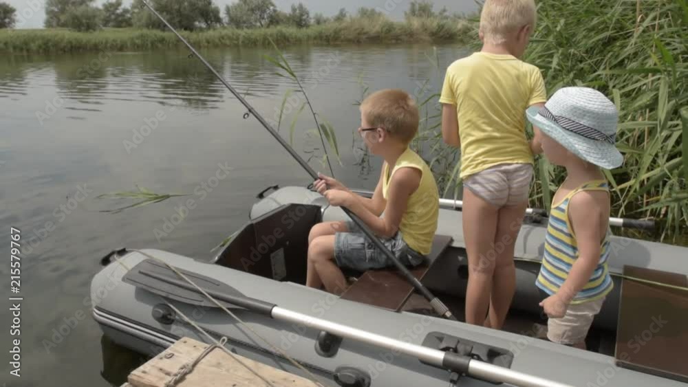 Happy children of village came to river to swim and fish. Boys are happy together on summer holidays in village. Reeds, wooden bridge, boat