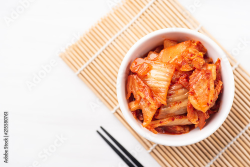 Kimchi cabbage in a bowl with chopsticks, top view, Korean food
