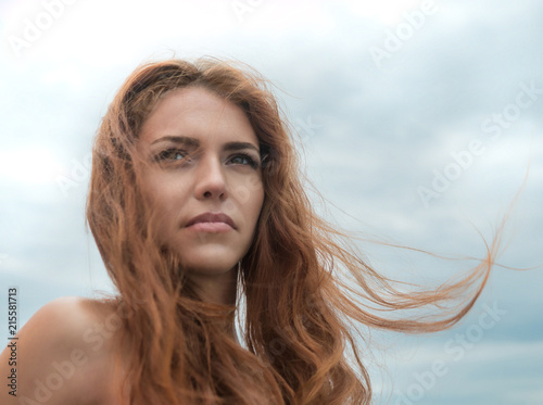 beautiful sharmed girl looking at the ocean in the summer beach. Smiling young woman on seaside. Happyness and freedom comcept