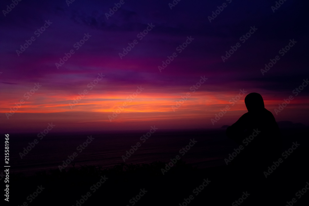Silhouette of man enjoying sunset over the Pacific Ocean on the coast of Miraflores neighborhood in Lima, Peru