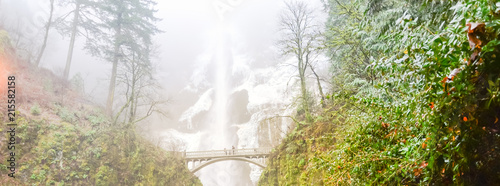 Panorama icy Multnomah Falls in winter time. It is a waterfall on the Oregon side of the Columbia River Gorge, along the Historic Columbia River Highway. Natural and seasonal waterfall background photo