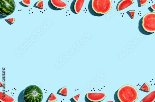 Whole and sliced watermelon border on a blue background