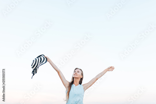 The girl was resting his hands up on the background of blue sky, concept of freedom, rest on fresh air