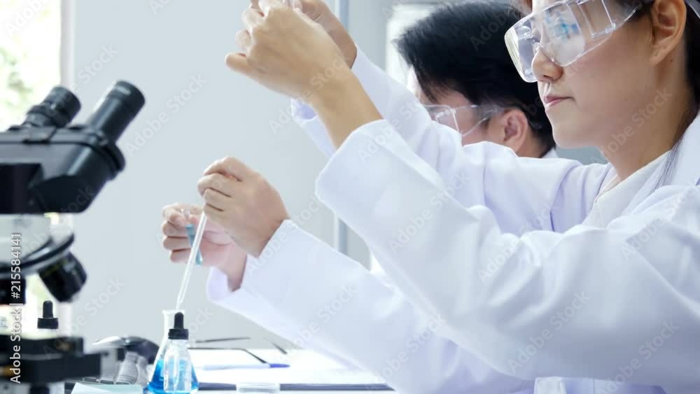 Asian Scientist looking to liquid in test tube. Science work at laboratory. People with medical, science, doctor, healthcare concept. 4K Resolution.