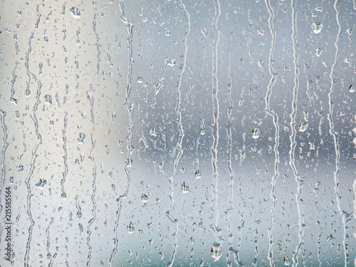 Rain drops on window glasses surface with blur building background. Natural Pattern of raindrops isolated on blur background.