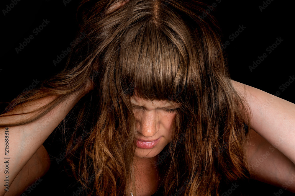 Depressed woman with hands in her hair Depressed woman with hands in her hair