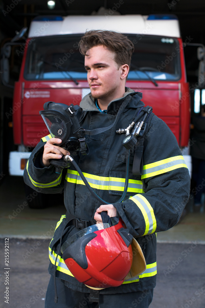 Portrait of a young fireman on the background of a fire truck Portrait of a young fireman on the background of a fire truck