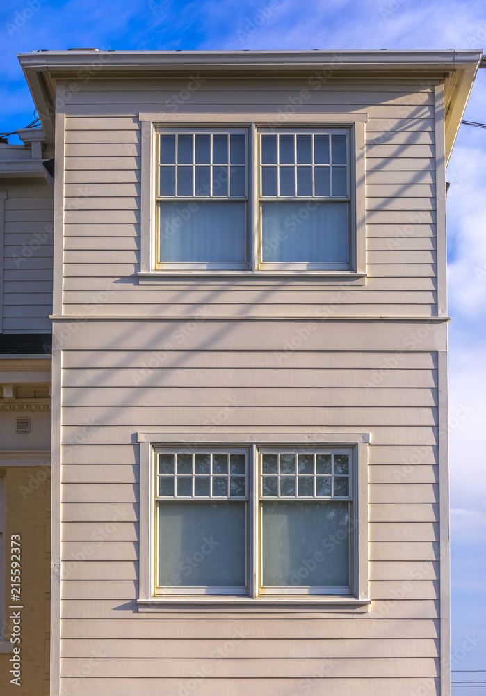 Two upper stories of white buildings with panels