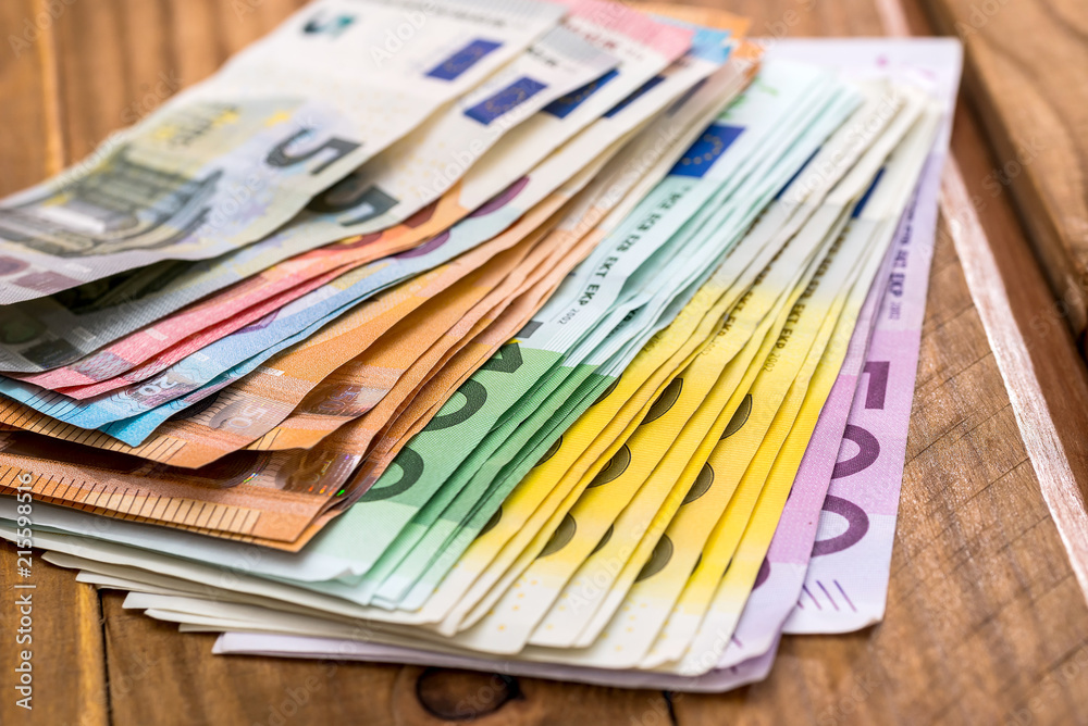 Stack of euro banknotes on wooden background