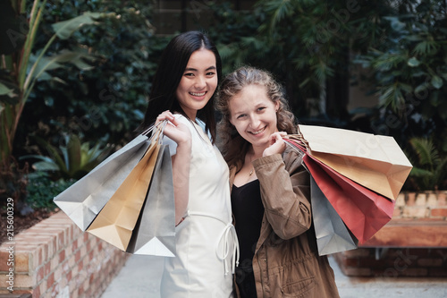 Young multicultural women holding shopping bags