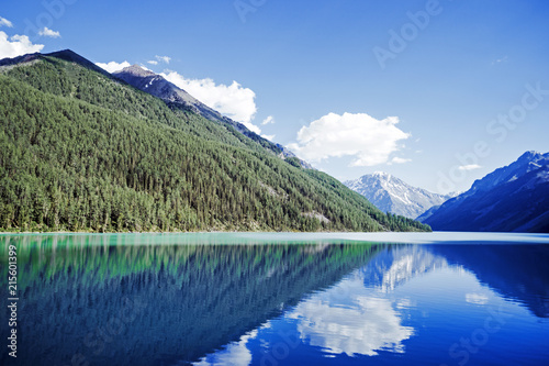 Russia, Altai, mountains. Beautiful blue lake kucherlinskoe in foreground against the snow-capped peaks of high mountains. Summer vacation in the mountains. reflection of mountains with snow-capped photo