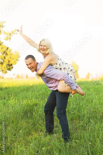 Cheerful loving woman and man spoiling on nature at sunset