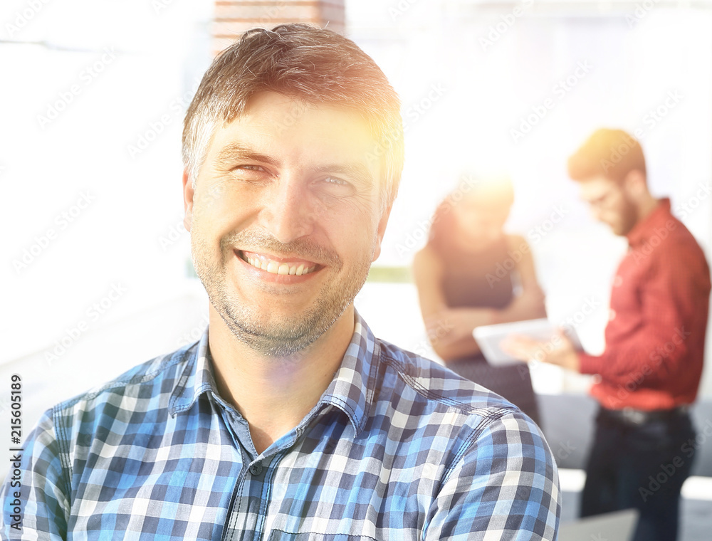 Casual businessman with arms crossed standing in the office