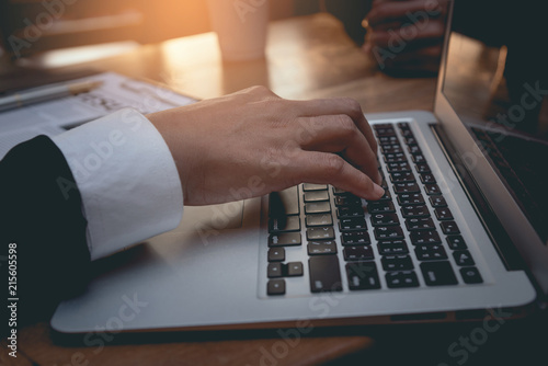 Businessman currently in contact and coordinate with customers online. His hands on the keyboard on a desk.