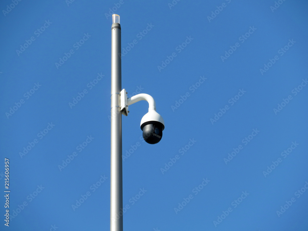 Outdoor surveillance video camera on a pole isolated on clear blue sky. Cctv camera, concept for security, antiterrorism and protection from crime Outdoor surveillance video camera on a pole isolated on clear blue sky. Cctv camera, concept for security, antiterrorism and protection from crime
