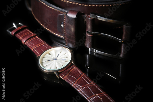 Men's accessories with brown leather wallet, belt and watch.