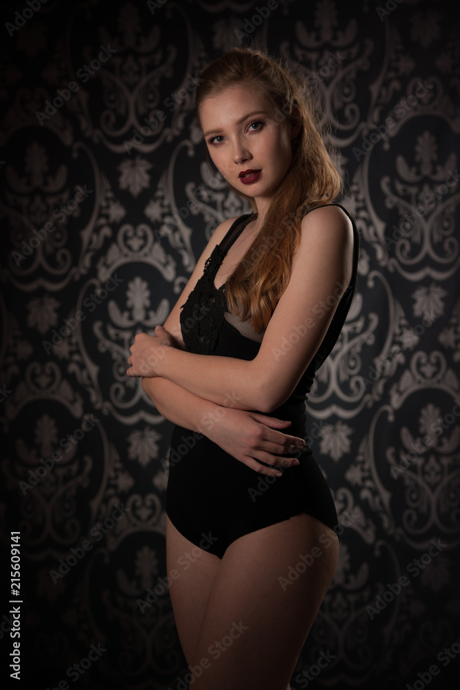 Boudoir photography of a beautiful young lady in black body over dark stylish background