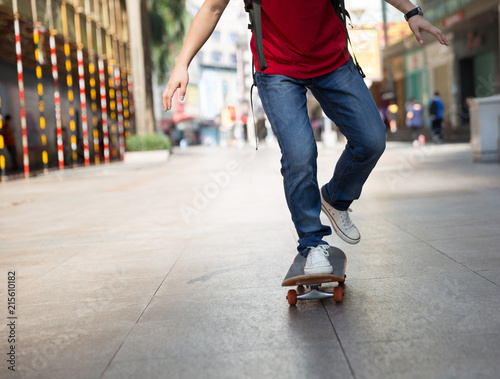 Skateboarder legs riding skateboard on city street © lzf