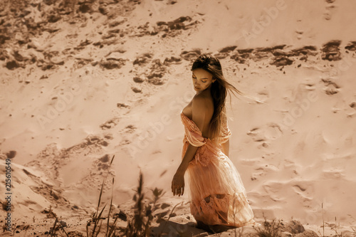 glamour brunette lady sits on a sand