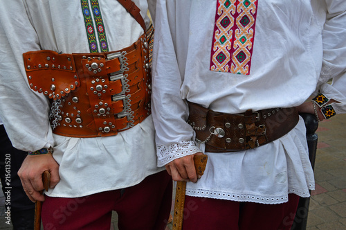 Two men in wide leather belts