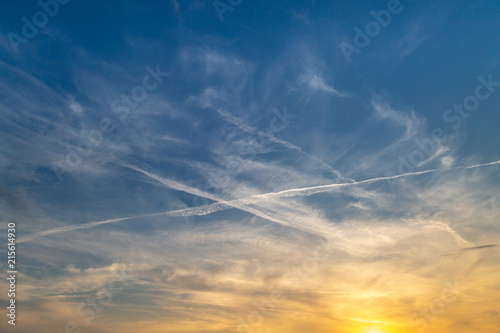 Looking up at a sunset sky and vapor trails