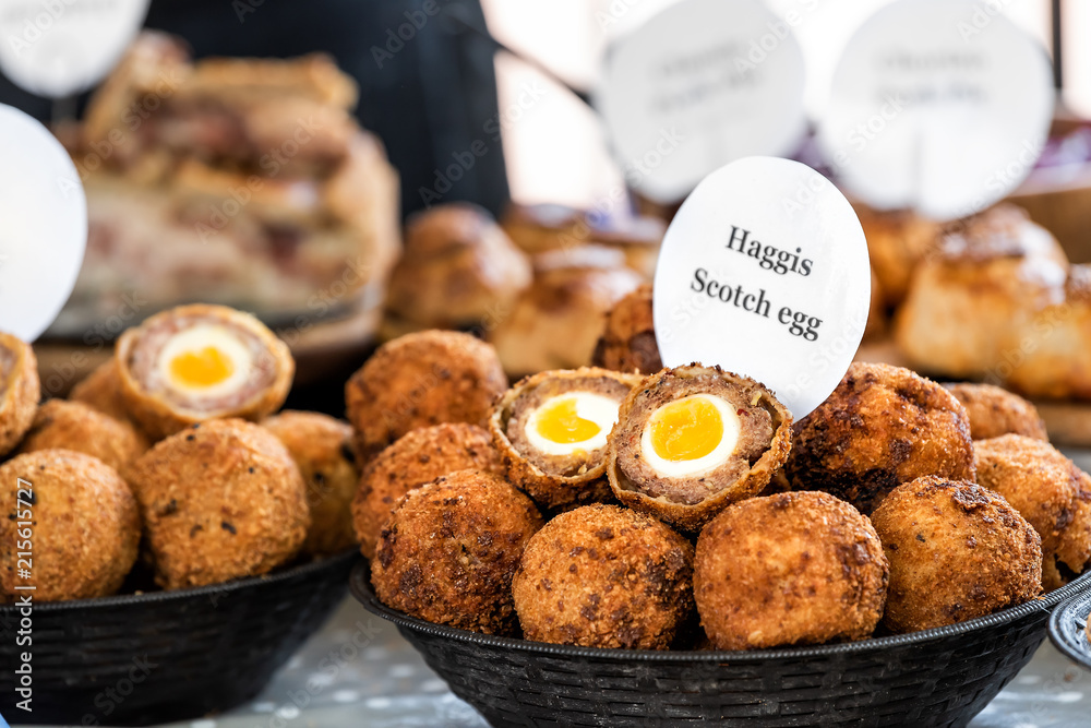 Closeup bowl of Haggis Scotch deep fried eggs with sign in market