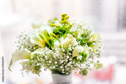 Closeup of flower bouquet in front of bright sunny window in room of hotel, many flowers arrangement