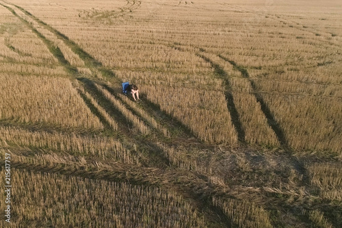 Sad tired young man sitting on the chair in the field. Aerial panoramic view.