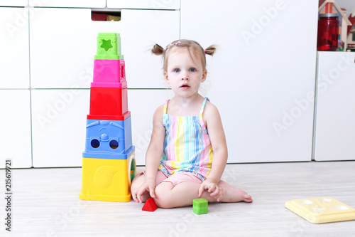 2 years toddler girl playing with educational toy at home on the floor