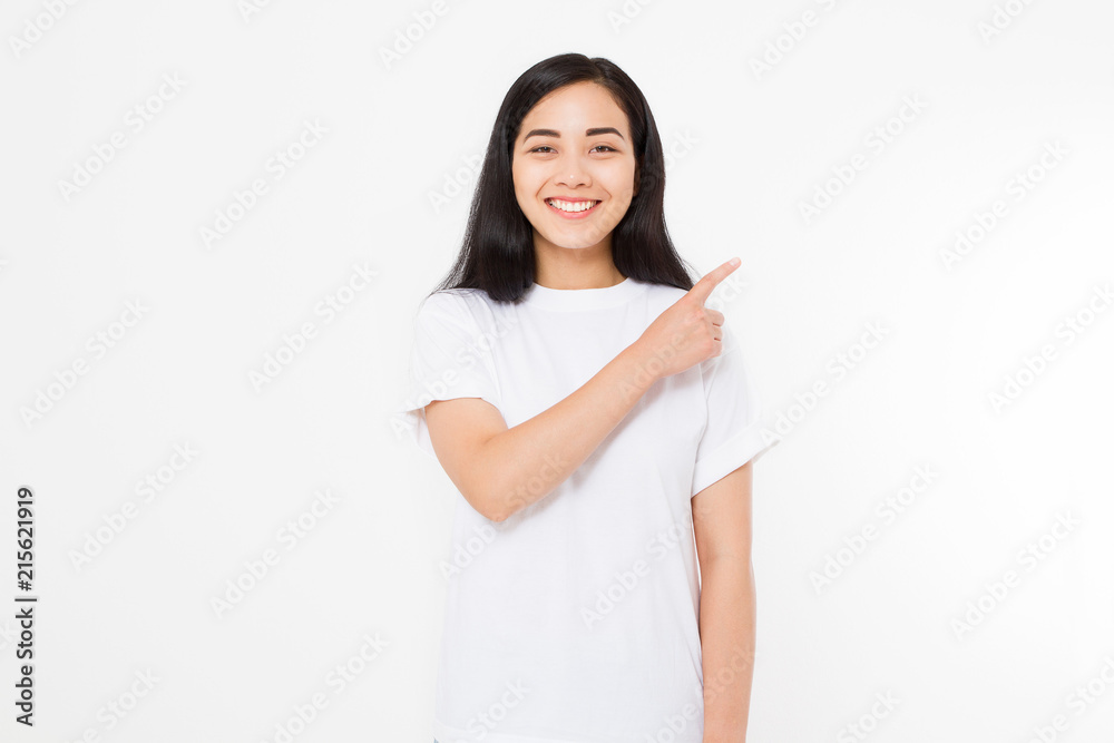 Portrait of smiling young asian woman wearing summer t shirt pointing at copy space by finger isolated on white template and blank background. Portrait of smiling young asian woman wearing summer t shirt pointing at copy space by finger isolated on white template and blank background.