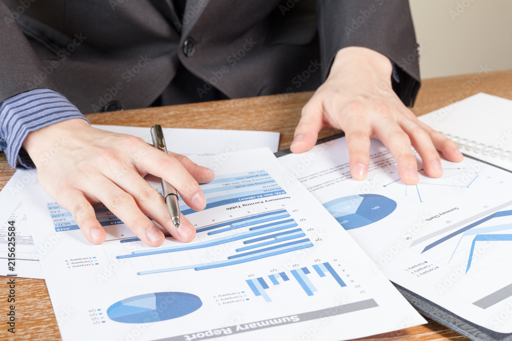 business man analyzing graph and chart document report business man analyzing graph and chart document report