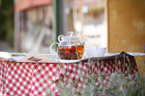 чайник заварной стоит на столе в кафе на улице 