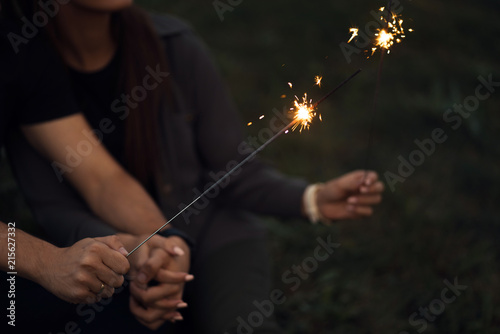 Couple holding sparkling lights in their hands