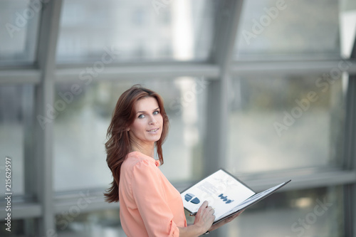 rear view.a young business woman holds a folder with financial documents © yurolaitsalbert