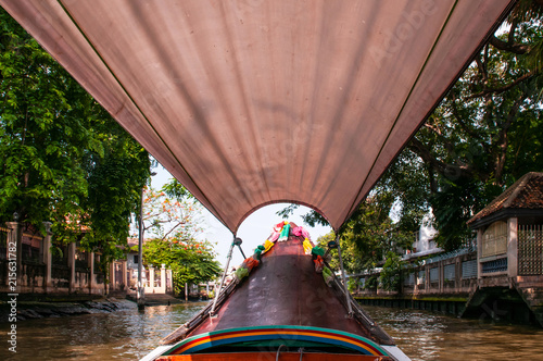 Photography Thai long tail boat with garlands in Bangkok canal (Klong), famous river transpo