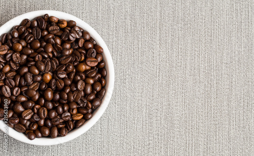 Coffee beans. Bowl of Aromatic Coffee on grey background, close-up. Flat lay