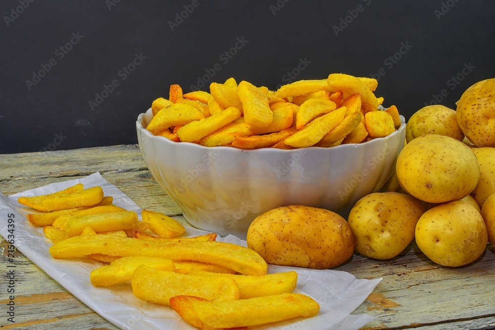 Homemade baked potato fries on white wooden board Homemade baked potato fries on white wooden board