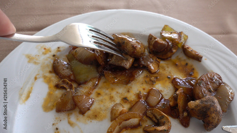 Point of view of a person who eats fried mushrooms in a Buffet restaurant. A man with a fork and a knife eats champignons. Eating and tasty and healthy food concept. Point of view of a person who eats fried mushrooms in a Buffet restaurant. A man with a fork and a knife eats champignons. Eating and tasty and healthy food concept.